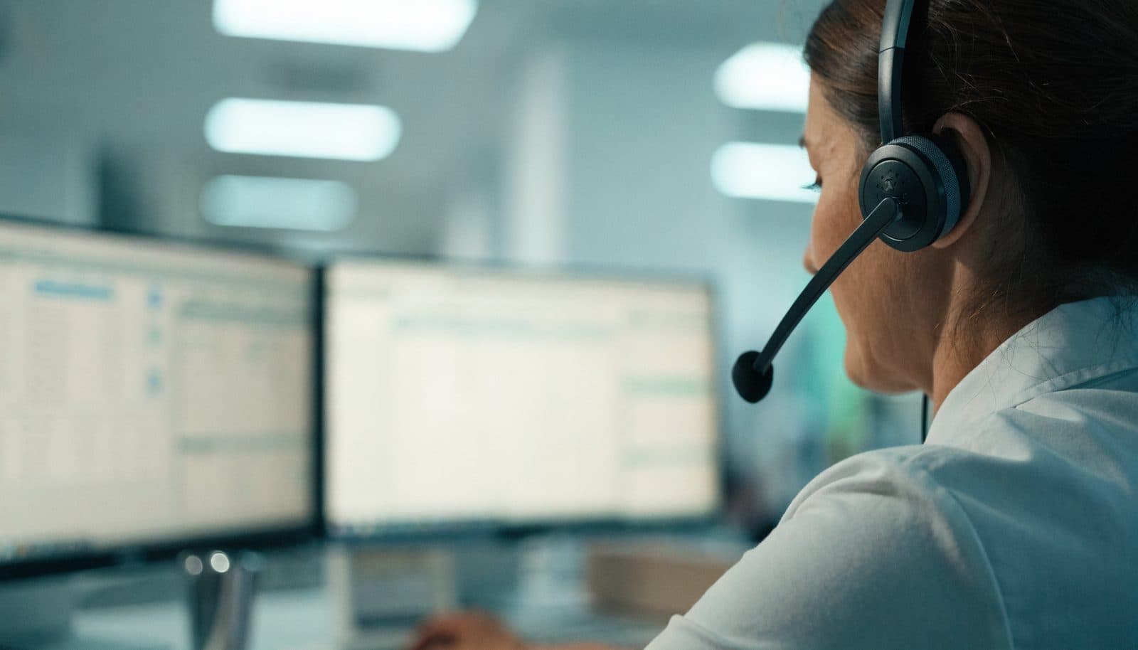 A care coordinator on a headset reviewing patient data on screen during a call